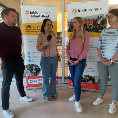 Drei Nordsee Mitarbeitende stehen mit Amy Zayed von Inklupreneur in einer Interviewsituation nebeneinander